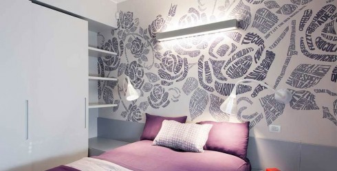 Pared de dormitorio decorada con papel pintado con detalles florales.